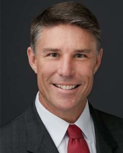 A man in a suit smiling
