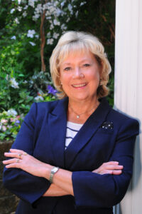 Pat Schou in front of a garden landscape