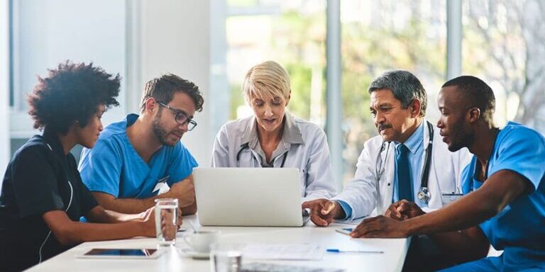 doctors meeting around laptop